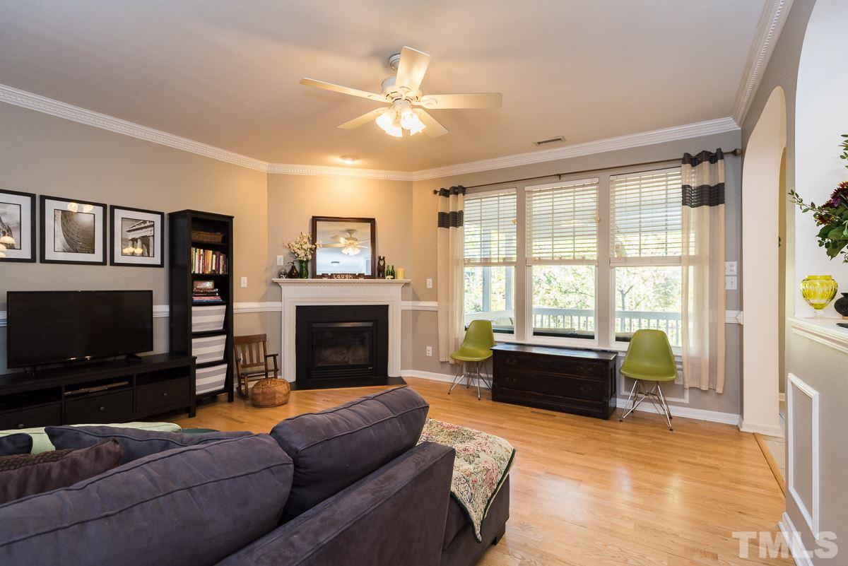 8516 Slabstone Court Raleigh, NC 27613 - Photo 8 of 30 a living room with furniture a flat screen tv and a fireplace