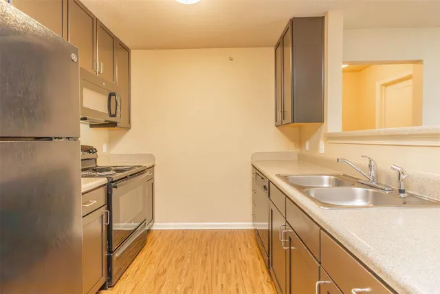 a kitchen with granite countertop a sink and a refrigerator