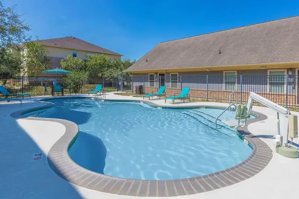 a view of a house with swimming pool and sitting area