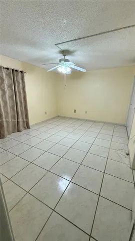 a view of a room with an empty space and a ceiling fan