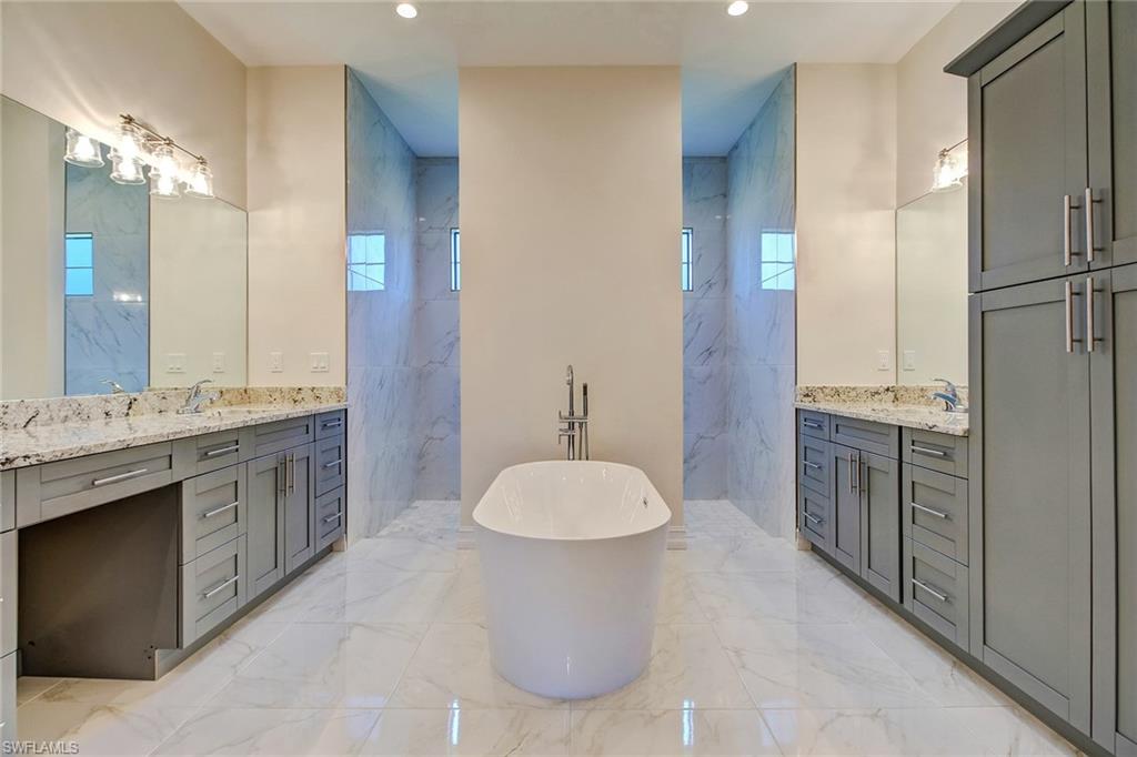 873 18th Street Northeast Naples, FL 34120 - Photo 14 of 25 a bathroom with a granite countertop sink a toilet and a mirror