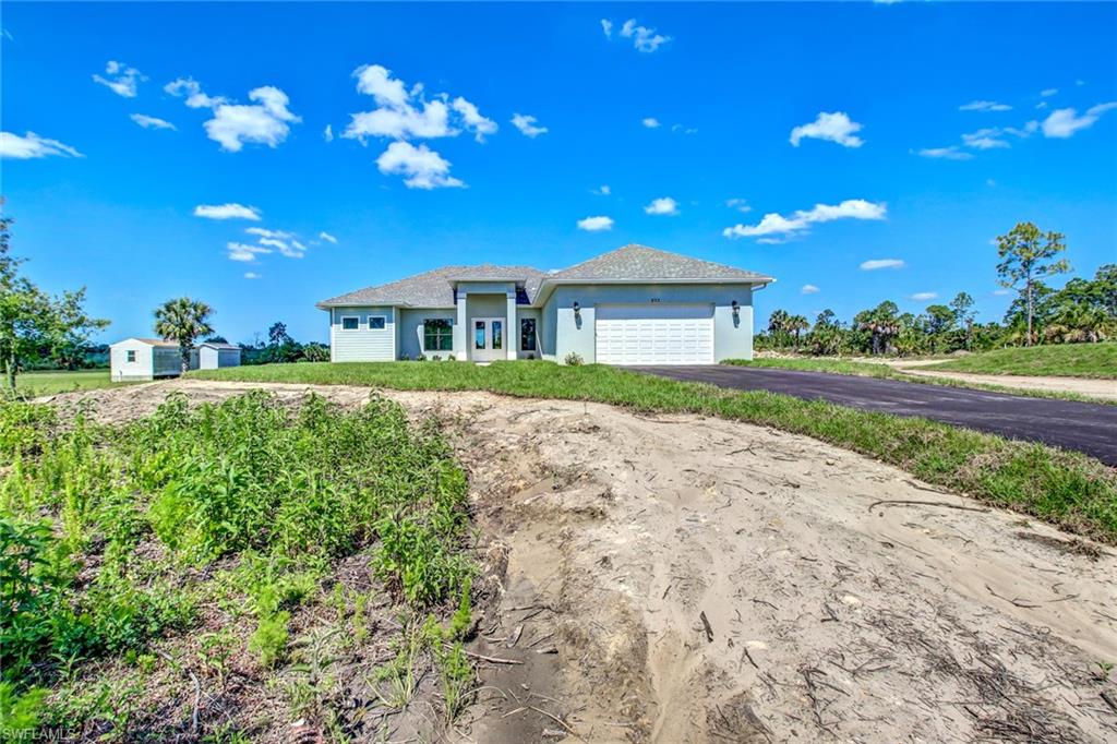 873 18th Street Northeast Naples, FL 34120 - Photo 2 of 25 a front view of a house with a yard