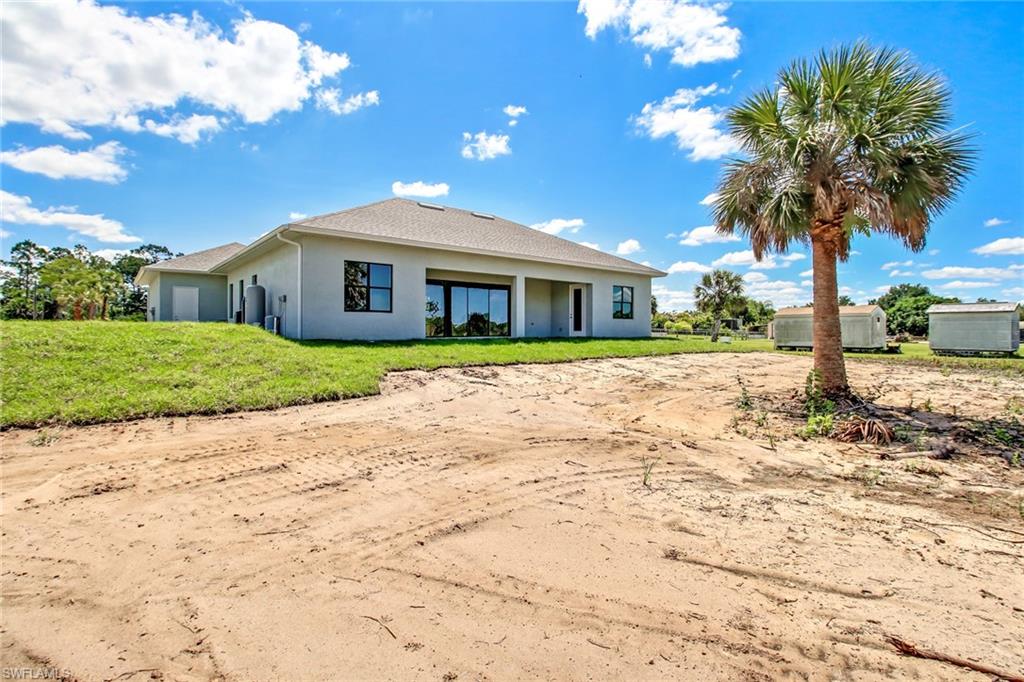 873 18th Street Northeast Naples, FL 34120 - Photo 25 of 25 a front view of a house with a yard and trees