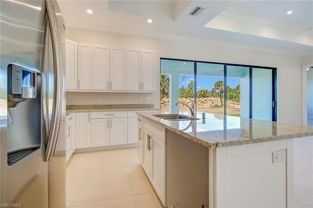 873 18th Street Northeast Naples, FL 34120 - Photo 8 of 25 a kitchen with stainless steel appliances granite countertop a sink and a refrigerator