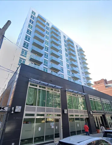 a view of a tall building next to a yard