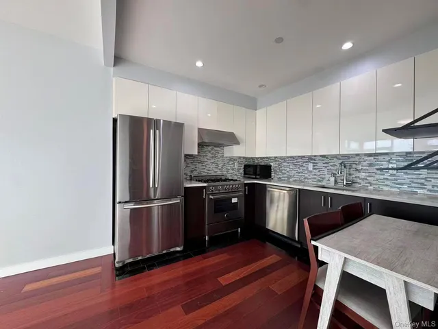 a kitchen with granite countertop a refrigerator and a stove top oven