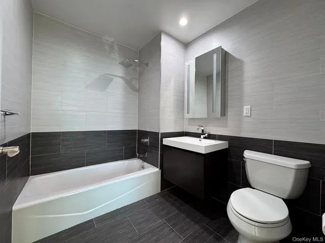 a bathroom with a sink a toilet a mirror and bathtub