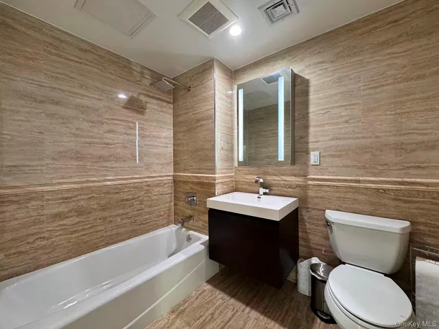 a bathroom with a toilet a sink and bathtub