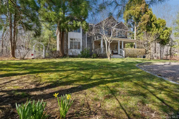 a view of a big house with a big yard and large trees