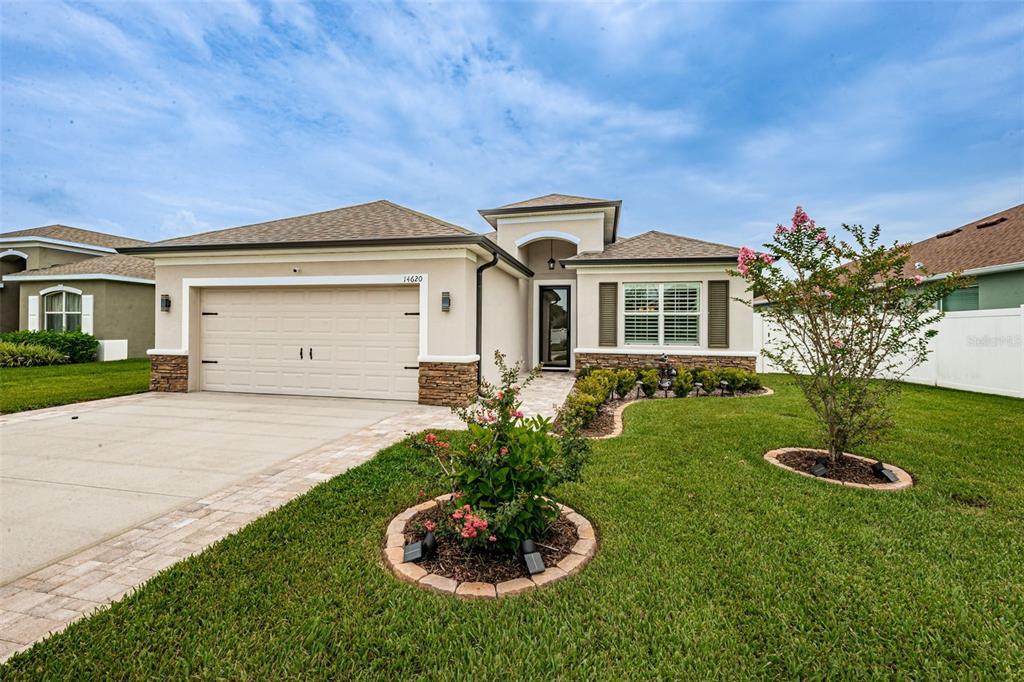 a front view of a house with a garden and plants