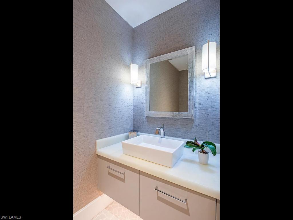 490 5th Street South, Unit 101 Naples, FL 34102 - Photo 22 of 34 a bathroom with a sink and a mirror