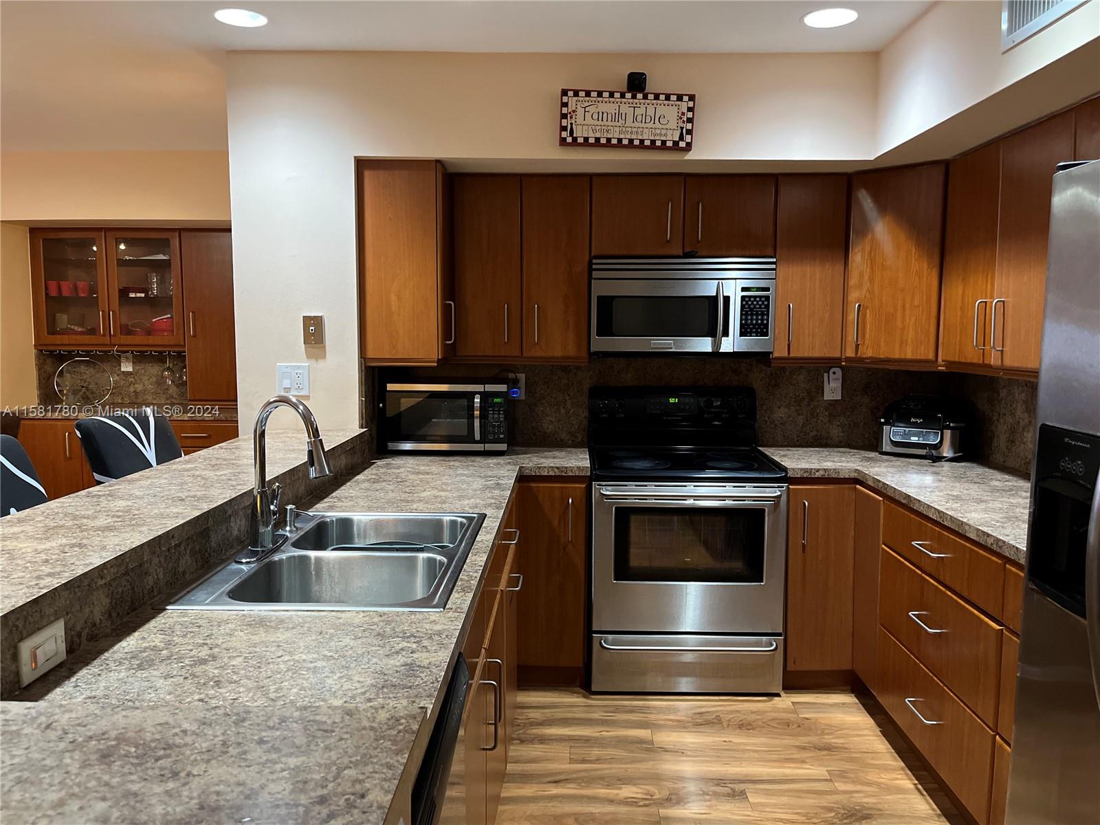 16500 Bridge End Road Miami Lakes, FL 33014 - Photo 6 of 17 a kitchen with stainless steel appliances granite countertop a sink and a microwave