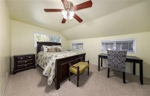 a bedroom with a bed a chair and a chandelier