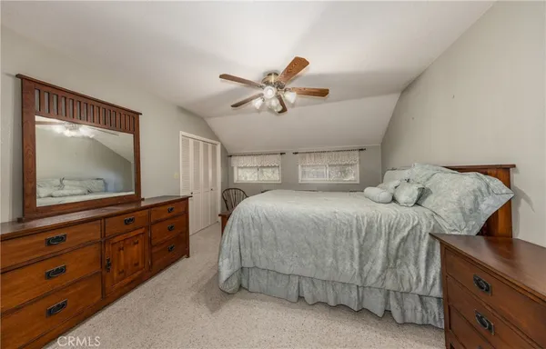 a bedroom with a bed and a large mirror on the dresser