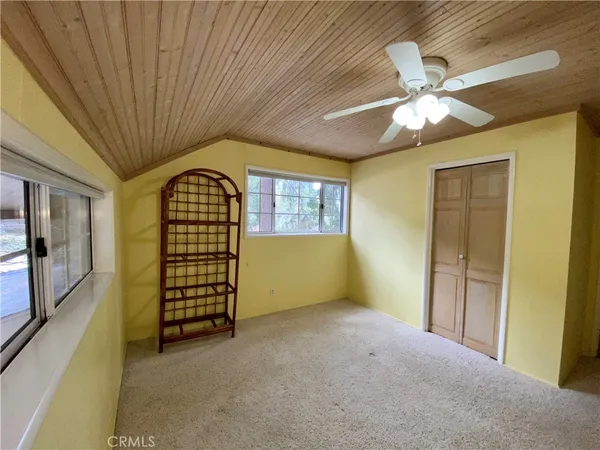 en empty room with windows and ceiling fan