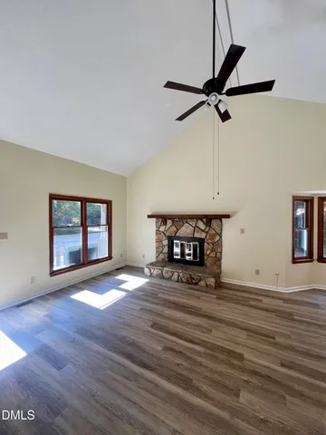 a view of an empty room with window and wooden floor