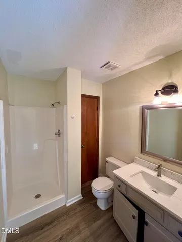 a bathroom with a granite countertop sink a toilet and shower