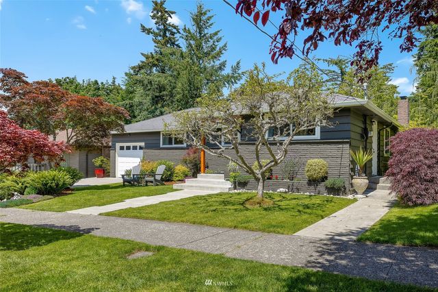 a front view of a house with a yard and trees