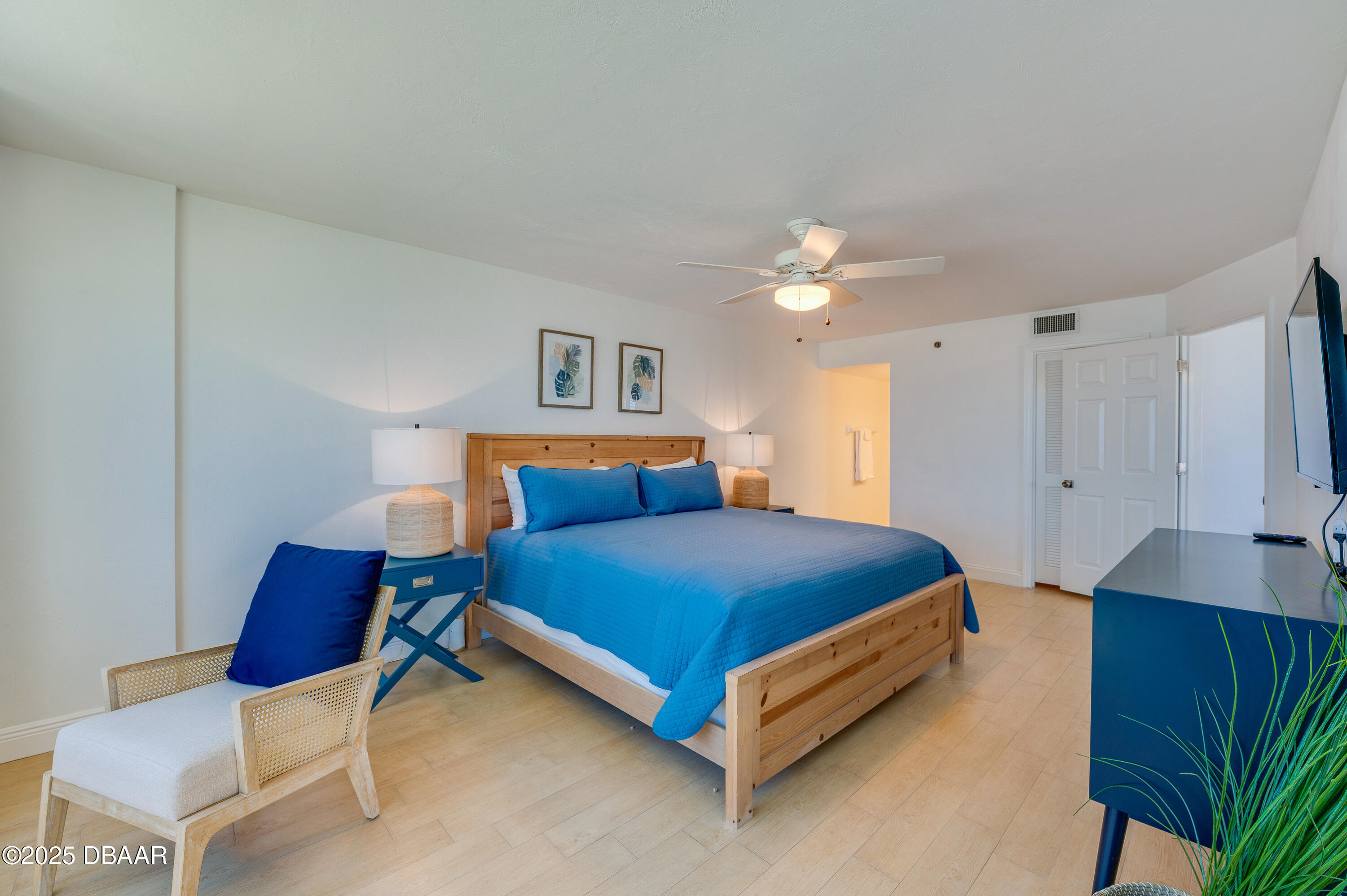 4545 South Atlantic Avenue, Unit 3206 Ponce Inlet, FL 32127 - Photo 17 of 35 a bedroom with a bed and a chandelier