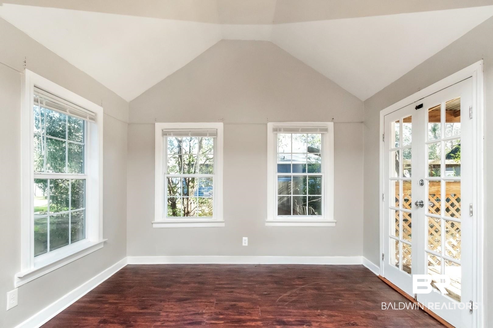 165 East Collins Street Mobile, AL 36606 - Photo 6 of 19 Empty room featuring lofted ceiling, baseboards, and dark wood-style flooring