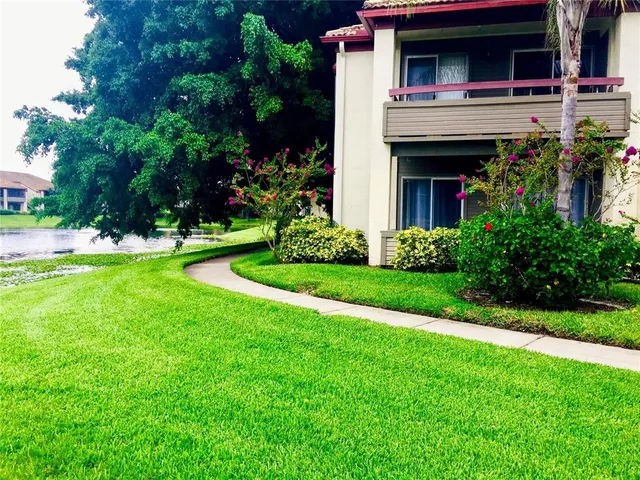 a view of house in front of a yard with potted plants