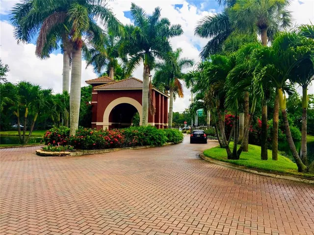 a front view of a house with a yard and potted plants