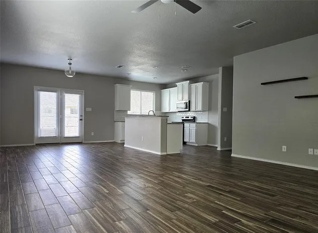 a view of a kitchen with wooden floor and a window
