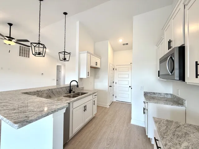 a kitchen with a sink stove and wooden floor