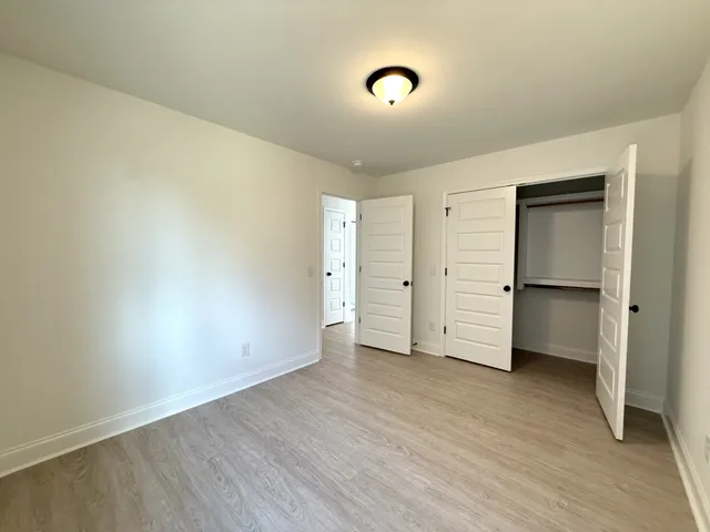 an empty room with wooden floor and closet