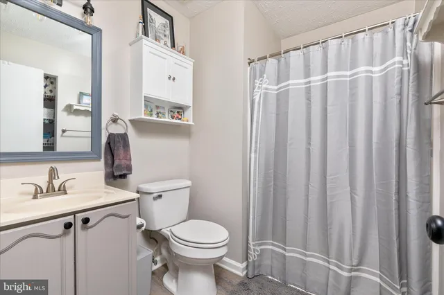 a bathroom with a toilet a sink and a mirror