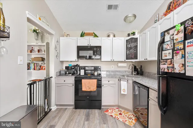 a kitchen with stainless steel appliances granite countertop a refrigerator and a stove top oven