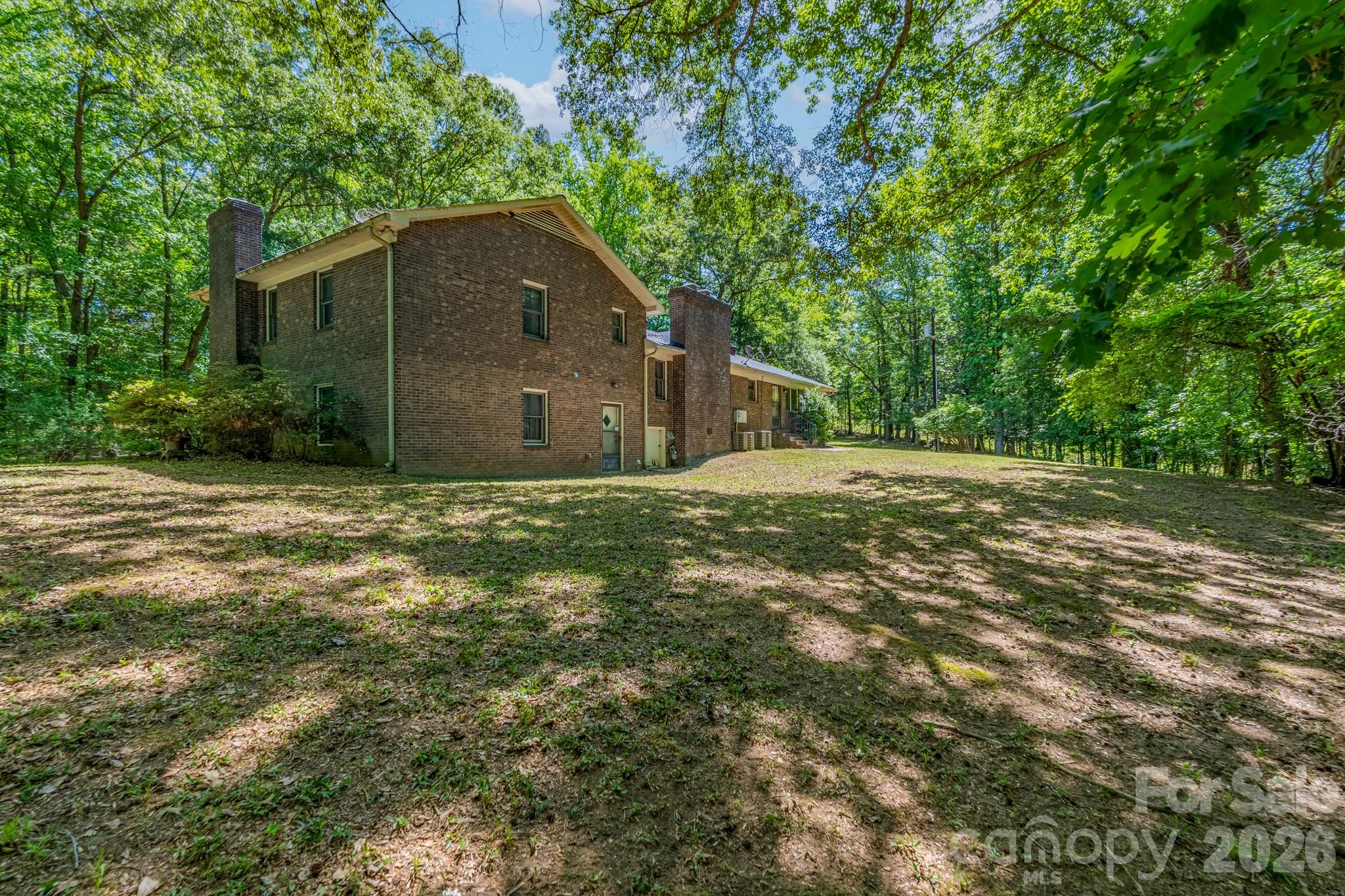 1836 Westbrook Road Edgemoor, SC 29712 - Photo 36 of 47 a backyard of a house with large trees and brick walls
