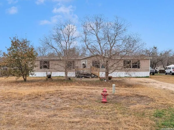 a backyard of a house with fire pit and trees