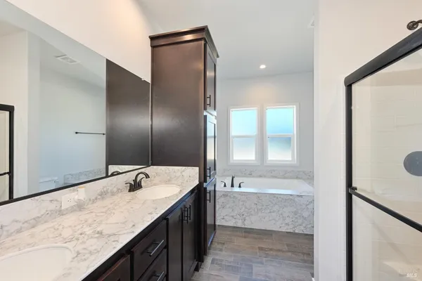 a bathroom with a granite countertop sink mirror and bathtub