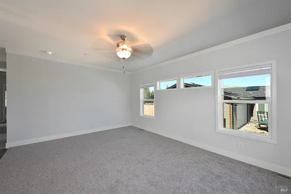 en empty room with windows and ceiling fan