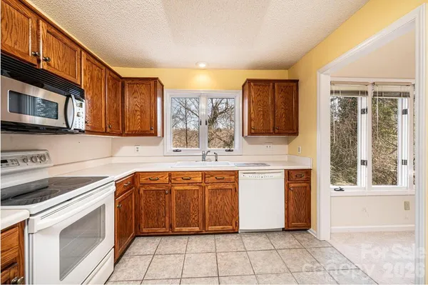 a kitchen with stainless steel appliances granite countertop a stove a sink and a microwave