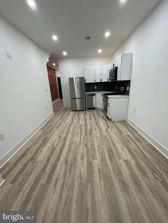a view of kitchen with refrigerator sink and cabinets