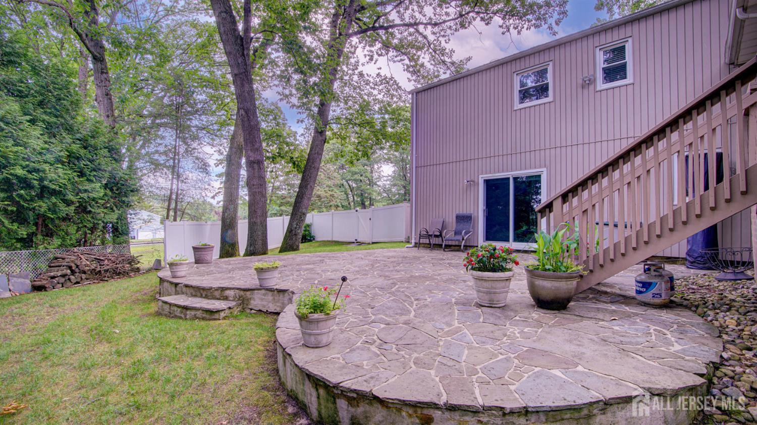 15 Timber Road East Brunswick, NJ 08816 - Photo 38 of 40 a view of a backyard with table and chairs potted plants and large tree
