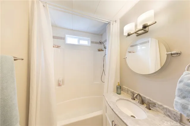 a bathroom with a granite countertop sink mirror and a bathtub