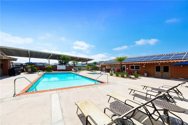 a swimming pool with outdoor seating and a tub