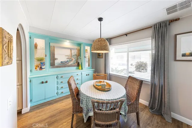 a dining room with furniture a chandelier and wooden floor
