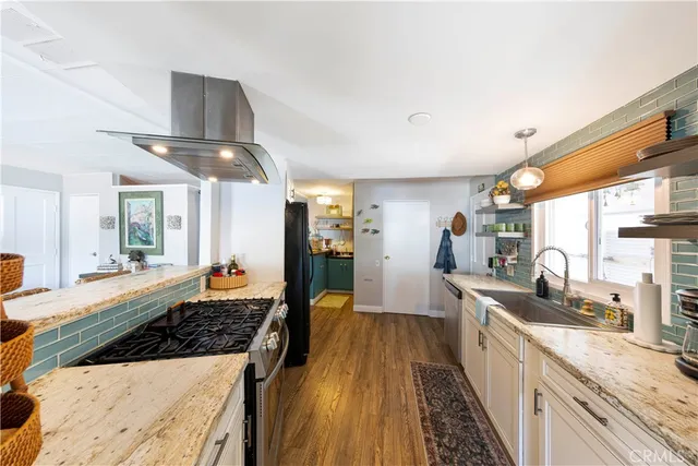 a large kitchen with kitchen island a large counter space a sink stainless steel appliances and cabinets