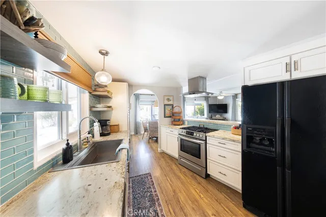a kitchen with granite countertop a refrigerator stove and sink