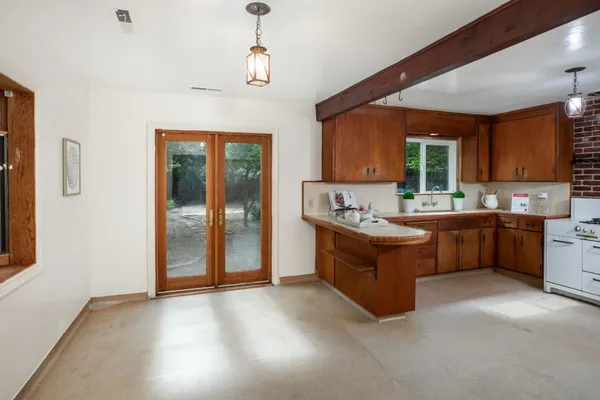 a room with kitchen island granite countertop lots of counter top space and stainless steel appliances