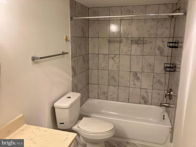 a bathroom with a toilet and a bath tub