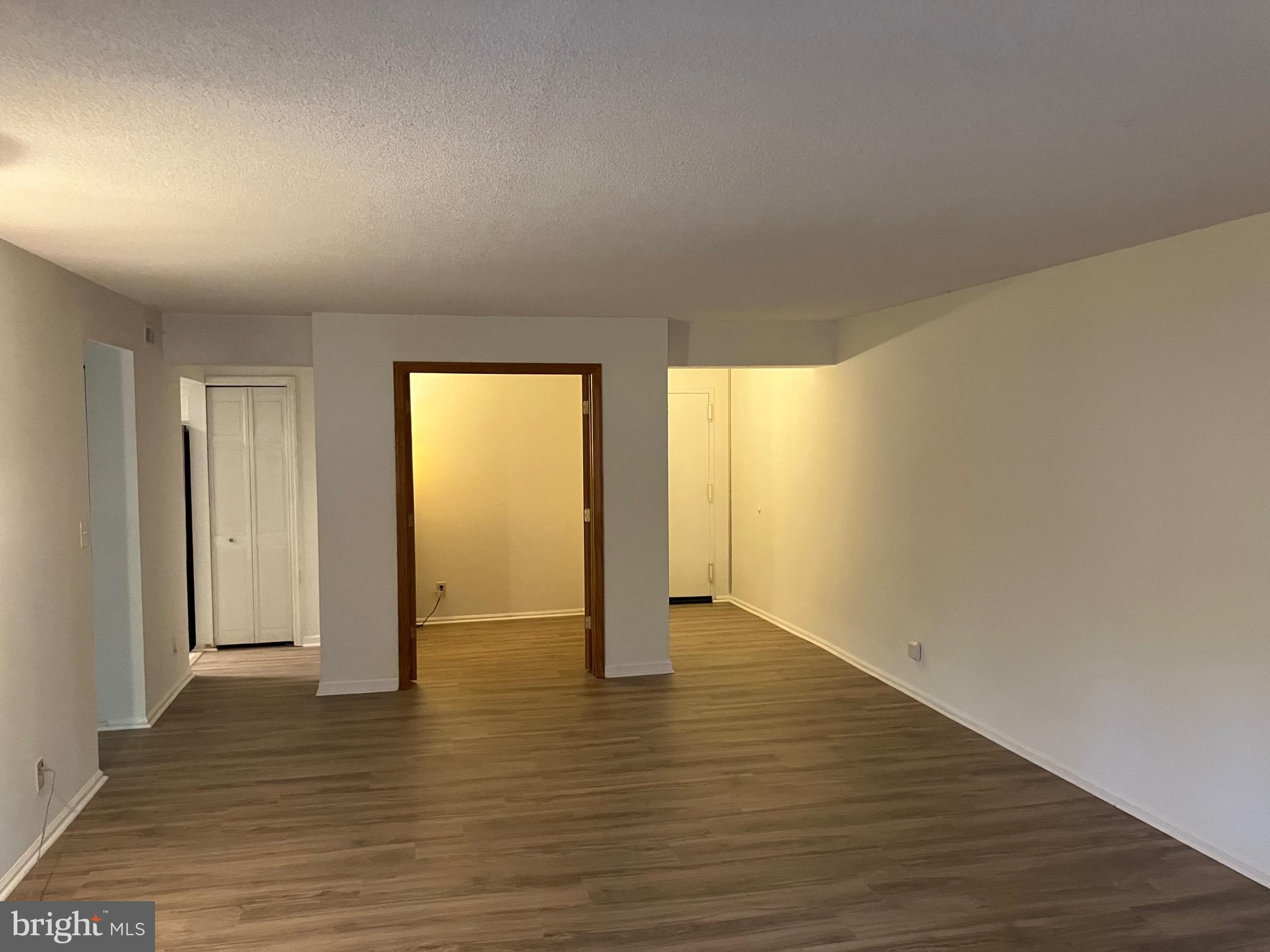 7680 Tremayne Place, Unit 201 McLean, VA 22102 - Photo 3 of 13 a view of an empty room with wooden floor and a window
