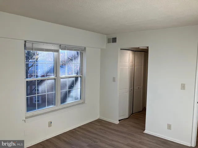 an empty room with wooden floor and a window