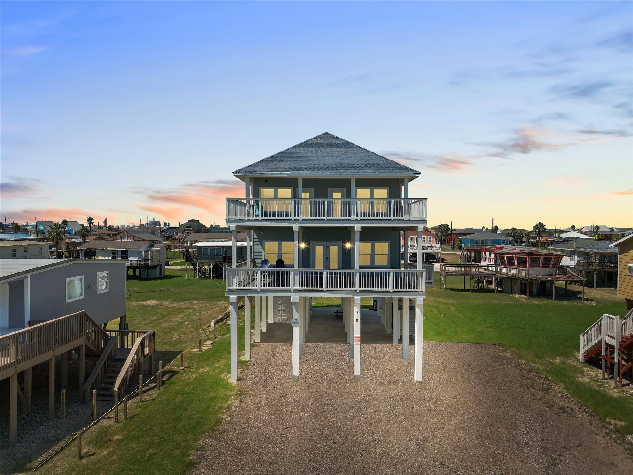 718 Beach Drive Surfside Beach, TX 77541 - Photo 46 of 49 This stunning coastal home boasts two expansive balconies, generous outdoor space, and a spacious driveway. Its modern, multi-level design offers breathtaking views and a warm, inviting atmosphere.