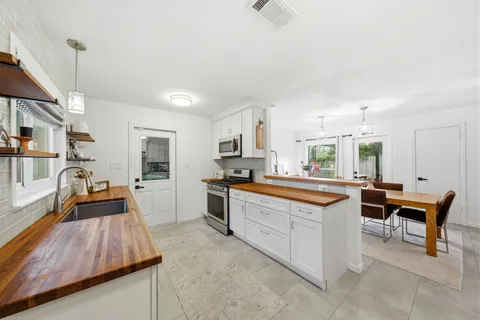 a large kitchen with cabinets table and chairs