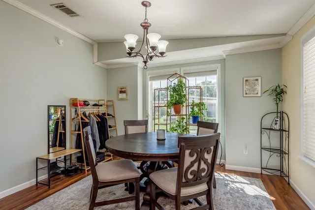a dining room with furniture a chandelier and wooden floor